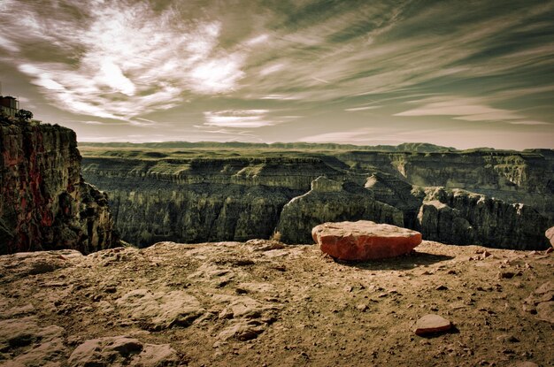 Photo view of rocks on landscape against cloudy sky