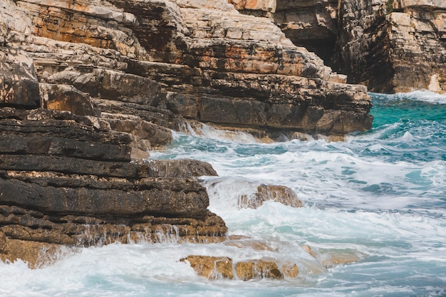 View of rocky seaside waves with white foam