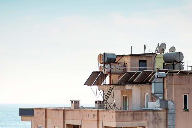 View of the roofs of houses with solar panels and water barrels. Concept Modern technologies, electricity savings.