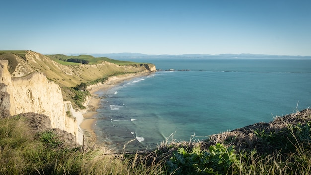 View on a rugged coast with cliffs and turquoise ocean waters