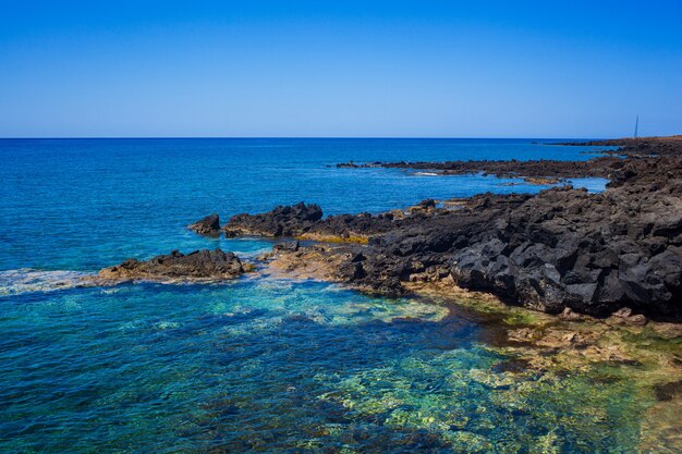 View of the scenic lava rock cliff  in the Linosa island. Sicily