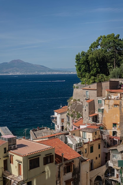 View of the sea and Mount Vesuvius through the old tiled roofs