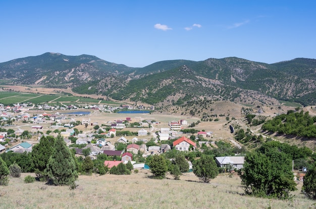 View of a settlement in a mountain valley houses outbuildings vineyards