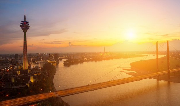 view of the skyline of Dusseldorfat at sunset with rhine tower (Rheinturm) and highway bridge. ideal for websites and magazines layouts