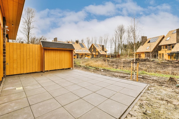 View of a small backyard of a modern cottage tiled in concrete color