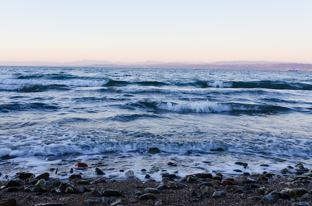 view of the snow covered Alps mountains against blue Adriatic Sea and sky in holidays. Slovenia