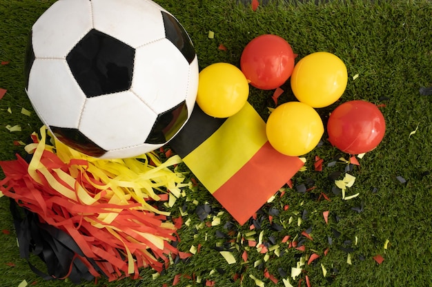 Above view of soccer ball and black yellow and red party favors