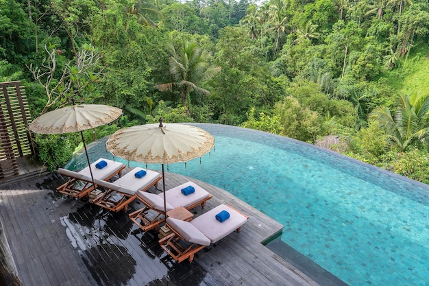 View of the swimming pool water and sunbeds in the tropical jungle near Ubud Bali Indonesia top view