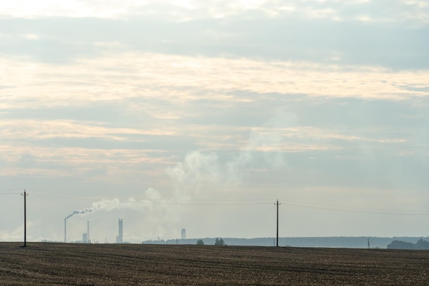 View of a thermal power plant or a factory for the production and processing of petroleum products Large industrial chimneys against a clear blue sky Removal of combustion