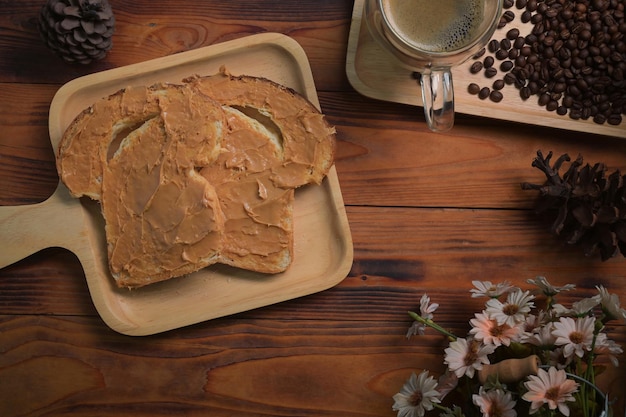 Above view toast bread with peanut butter on wooden background