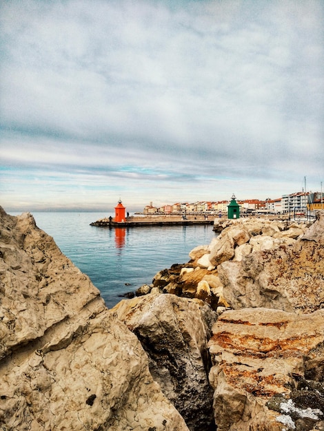 view of the town of Piran with main square of Tartini, old buildings with red roofs, Adriatic sea.