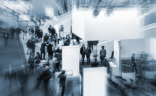 View of a trade fair crowd on a exhibition with fair booths. copyspace for your individual text.