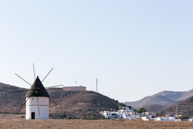 View of a typical windmill Cabo de Gata with a village background Almeria Spain