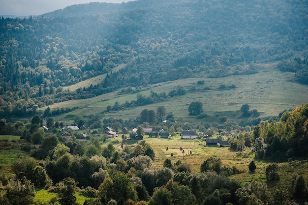 View to the valley with the village High mountain Summer landscape Meadow with huge forest trees a country near the peak of the mountain range