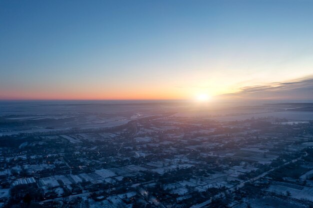 View of the village from a height small private houses glowing in the evening winter sunset