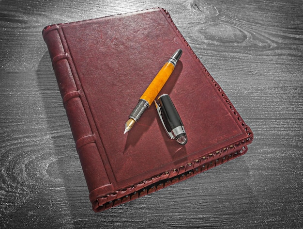 View on vintage leather notepad and opened fountain pen