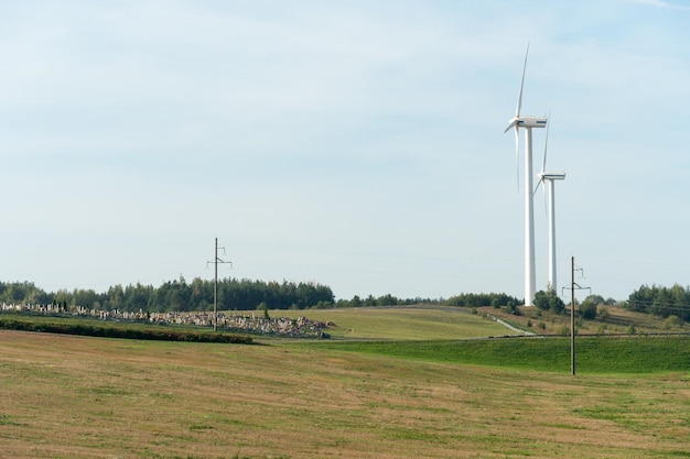 View of the windmill against the blue sky Wind turbines in the field or along roads Renewable energy source Use of natural resources for the benefit of humanity