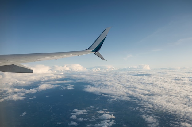 View of wing airplane on cloudy in blue sky, travel on vacation