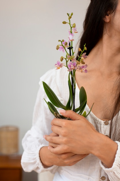 View of woman decorating her home with orchid flower