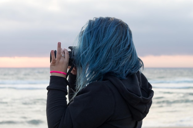 Photo view of woman photographing sea against sky