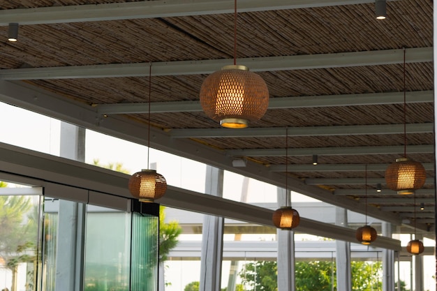 View of wooden lanterns hanging from a bamboo ceiling