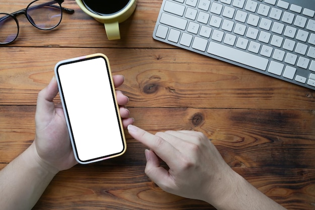 Above view young man using smart phone on wooden desk