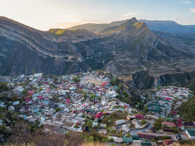 The village on the mountain. High-altitude plateau with a Gunib town and mountain serpentine with green rocky terraces. High mountain valley in Dagestan. Russia.