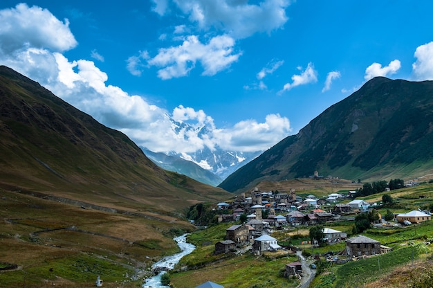 Village Ushguli landscape with massive rocky mountains Bezengi wall, Shkhara on the background in Svaneti, Georgia