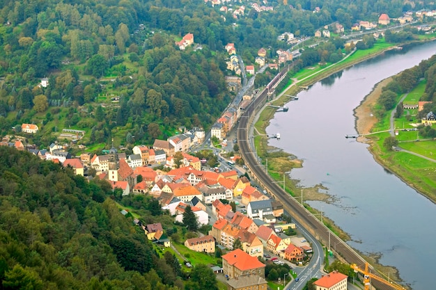 The village with houses near the river and green forests View from above