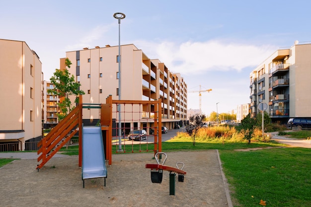 Vilnius, Lithuania - October 9, 2018: Apartment residential house facade architecture and child playground and outdoor facilities. Blue sky on the background.