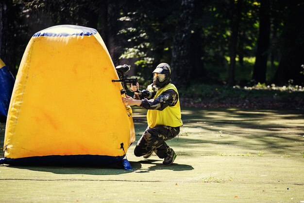 VinnitsaUkraine August 222016Young man Paintballerin protective uniform and mask in extreme process of paintball game