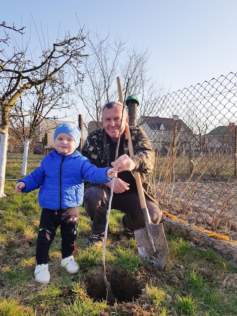 Vinnytsia Ukraine May 1 2022 A little boy with his grandfather in the garden