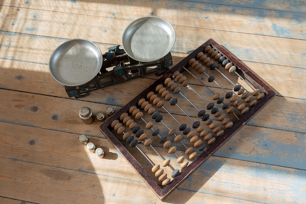 Vintage abacus and scales with weights on the wooden floor