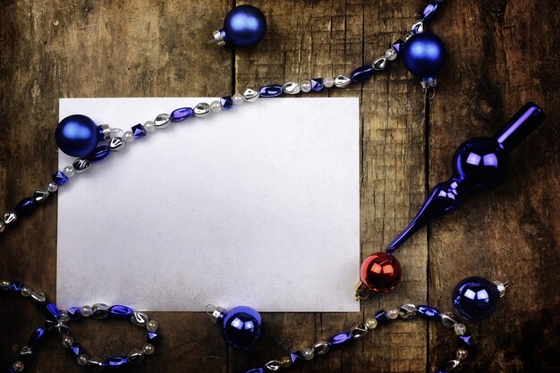 Vintage background christmas ball toy on a wooden table and a blank sheet of paper