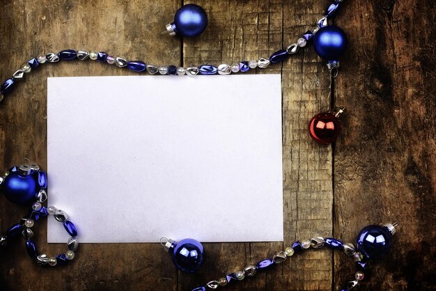 Vintage background christmas ball toy on a wooden table and a blank sheet of paper