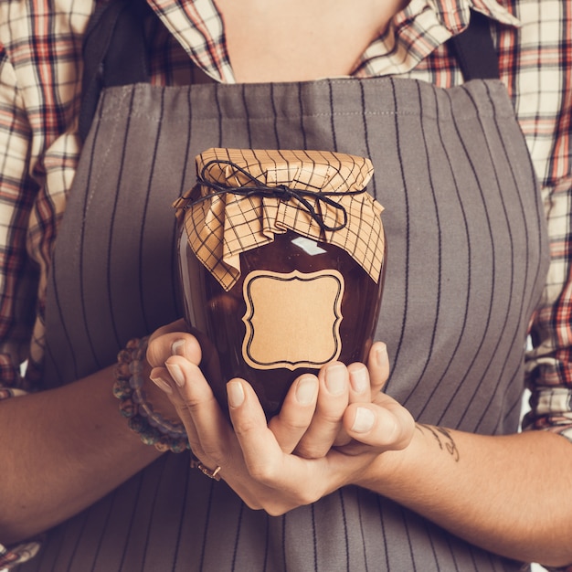 Vintage Bank peach jam in the hands of women. Close-up