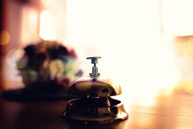 Vintage bell stands on wooden counter to attract attention