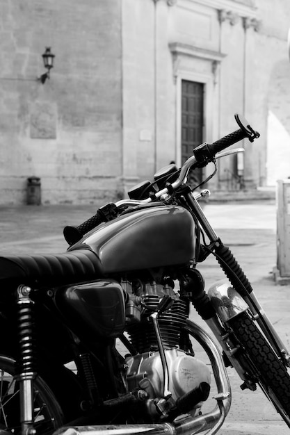 Vintage black motorcycle standing in the street of old italian town Lecce Apulia Italy