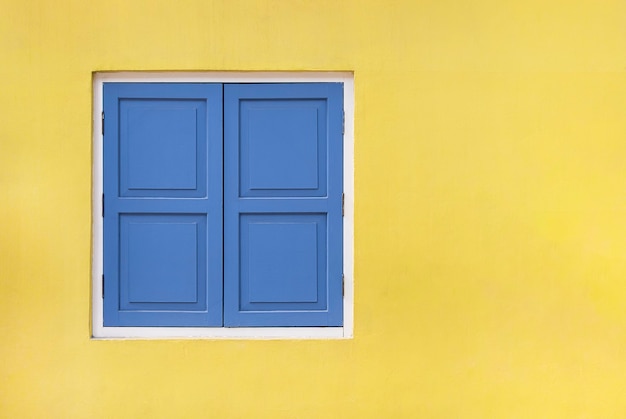 Vintage blue shutters and wooden windows isolated on yellow with copy space and clipping path