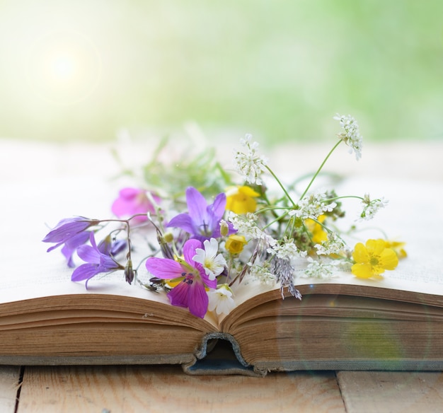 Vintage book with bouquet of meadow flowers nostalgic background