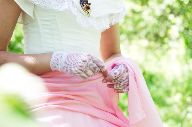 Vintage bride in gloves in a whitepink dress with a retro brooch