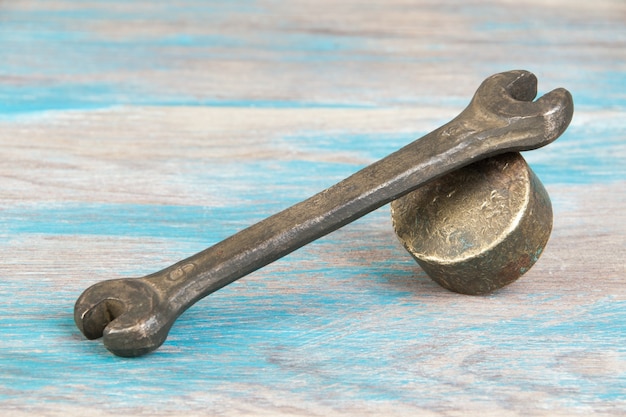 Vintage bronze wrench on shabby blue wooden background. Copy space for text.