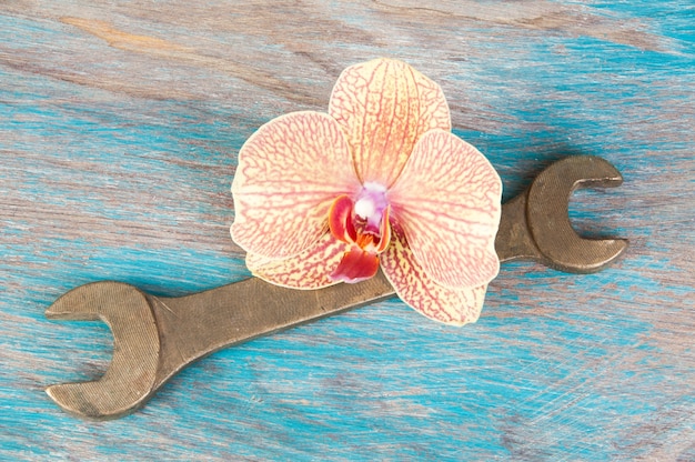 Vintage bronze wrench on shabby blue wooden background. Copy space for text.