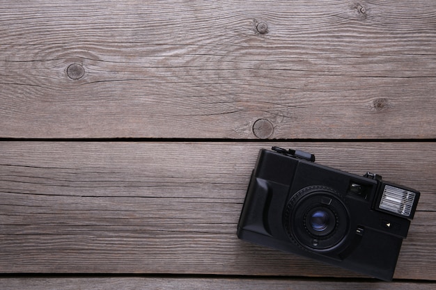 Vintage camera on grey wooden background.