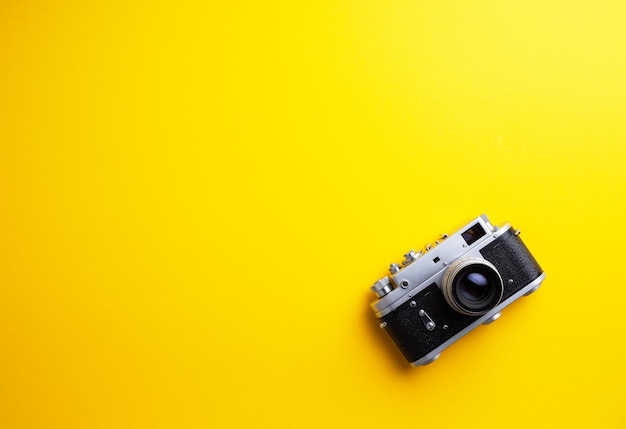 Vintage camera over yellow background with negative space