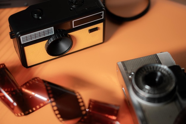 Photo vintage cameras and film on orange background