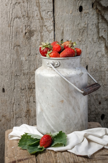 Vintage container with large ripe garden strawberries on wood