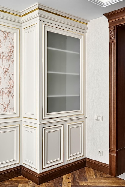 Vintage display case with crown molding and glass door in classic style near wooden doorway