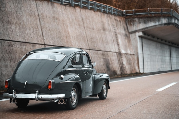 Vintage European Beauty in Motion Blue Oldtimer Coupe Speeding Along the Public Highway Old vintage European car model on the streets