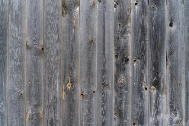 Vintage fence of old wooden boards Texture of an aging wooden surface Beautiful wooden background